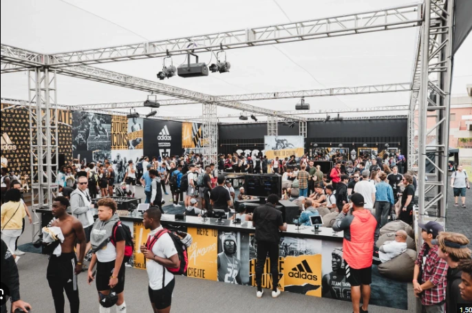 Crowds engaging with an adidas branded fan activation, with event structures, signage and interactive spaces